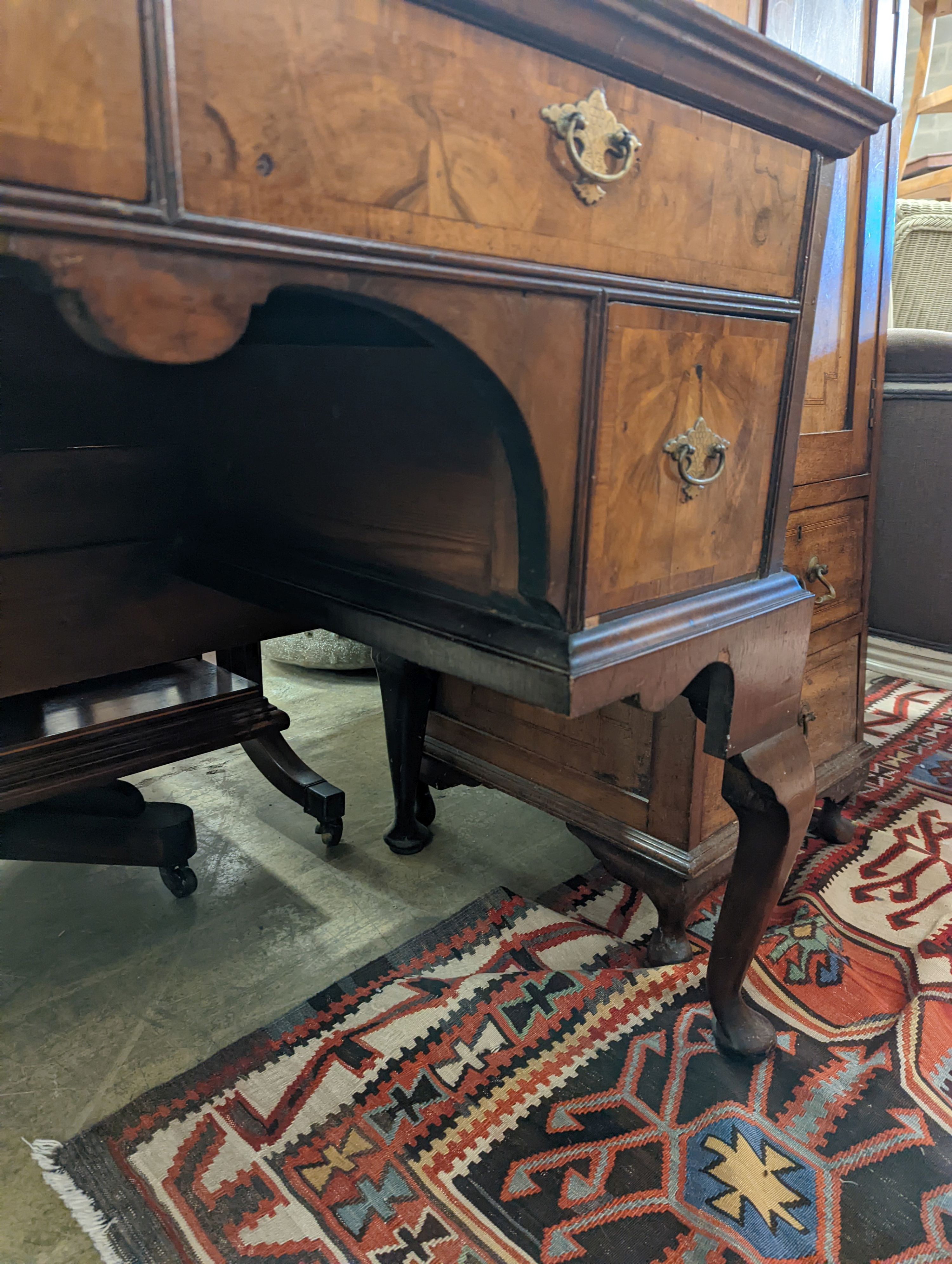 A Queen Anne revival banded walnut kneehole dressing table, width 102cm, depth 48cm, height 75cm